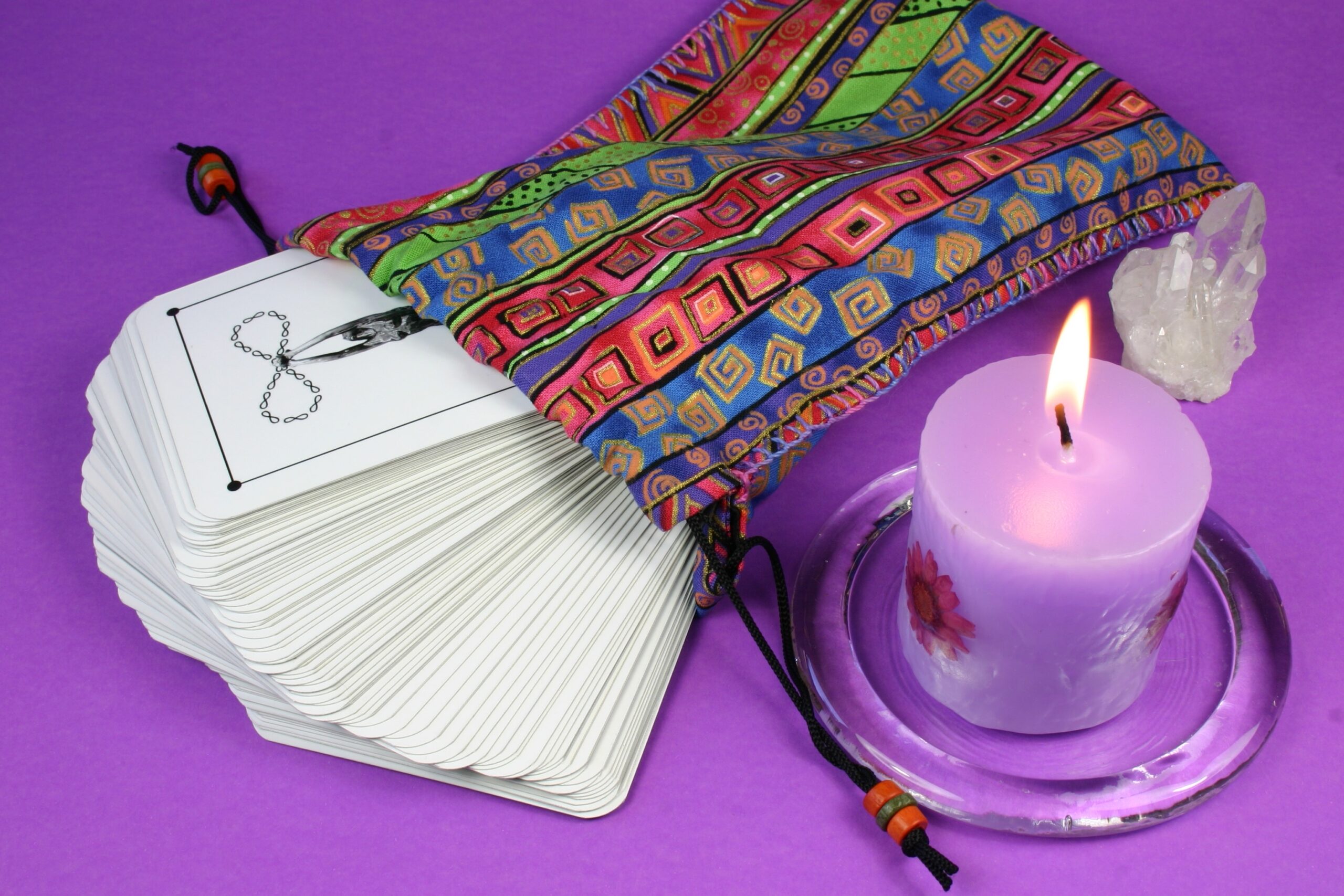 Tarot cards are fanned out beside a colorful bag