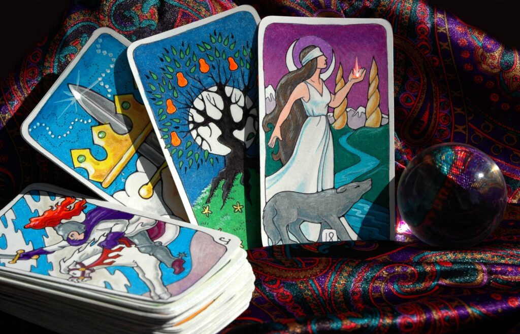 Colorful tarot cards featuring a queen, a mystical scene with a wolf